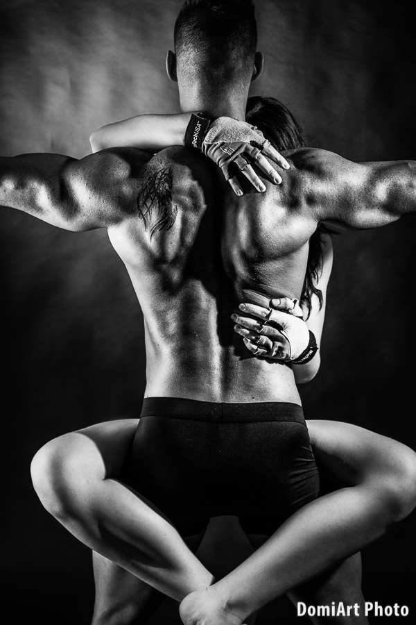 a férfi háttal áll, a nő felugrott az ölébe, átkulcsolta a nyakát - fitness fotózás debrecen