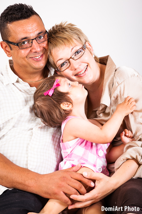 Műtermi családi fotózás - anya, apa és a kislányuk. Közeli, életteli családi portré.