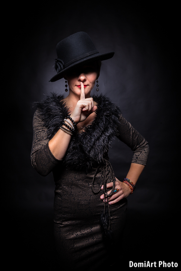 fekete hátteres portréfotózás női modell kalapban
