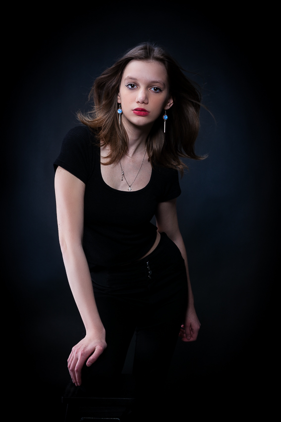 szélgépes modell fotó - editorial kategória, ügynökségi jelentkezéshez, profi retussal, modell ül a széken és oldalra fordulva pózol harisnyában és bodyban - portfólió készítés debrecen